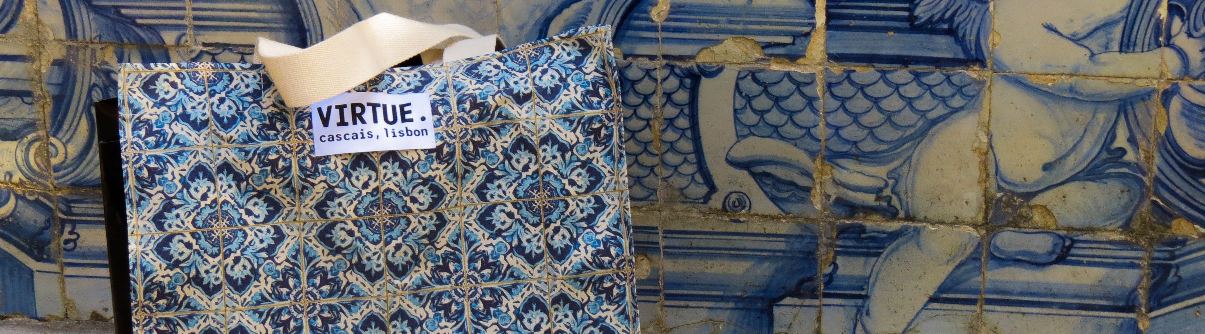 Two blue patterned bags with 'Virtue' labels against a decorative tile wall.